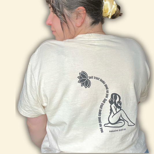 Person wearing a white t-shirt with graphics and text on the back